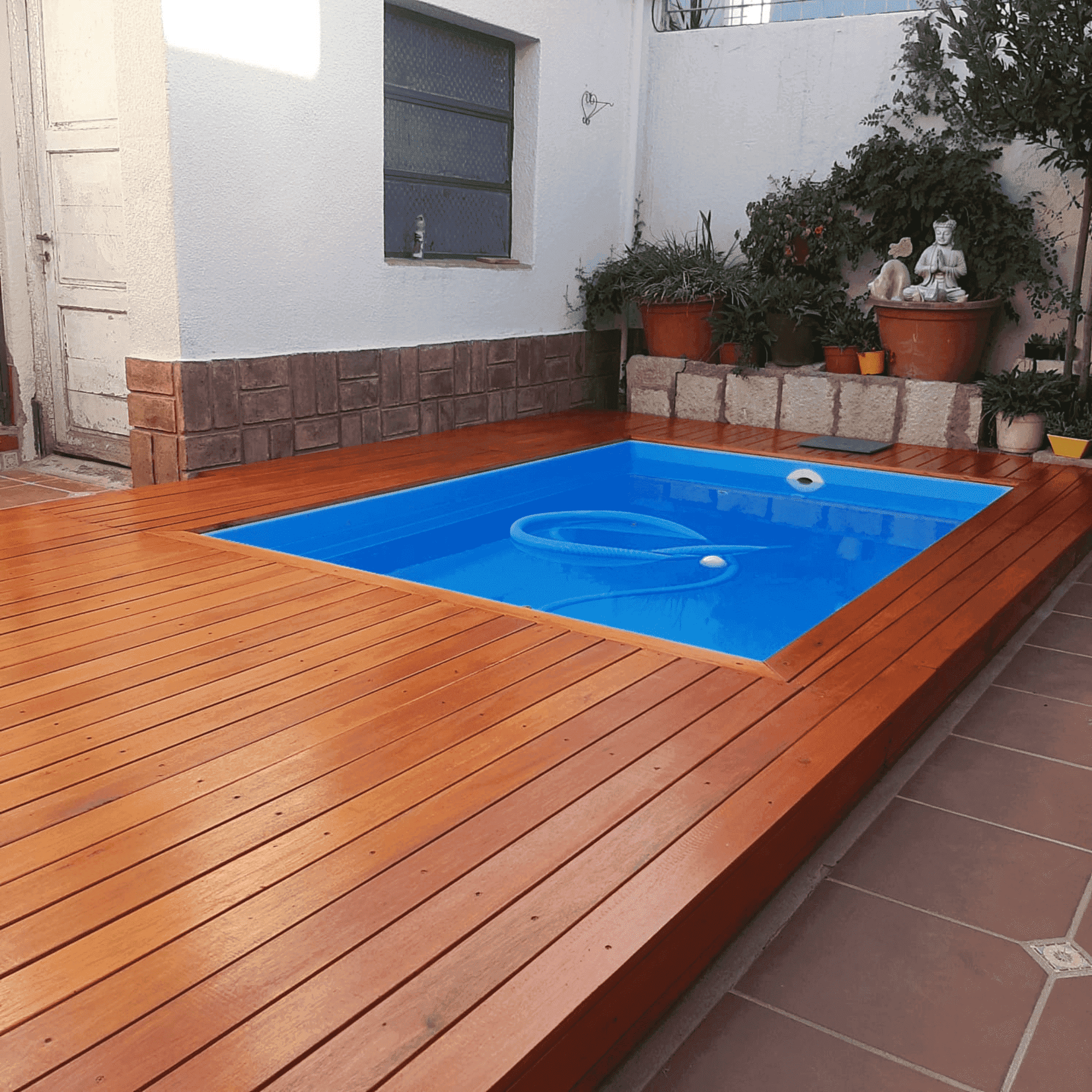deck color cedro intenso, al lado de una pileta